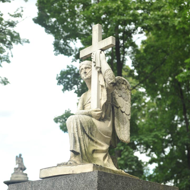 gravestone depicting angel holding the cross