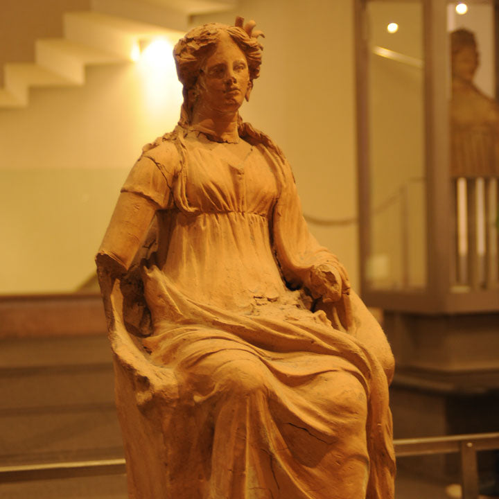 a female statue in a reddish terracotta